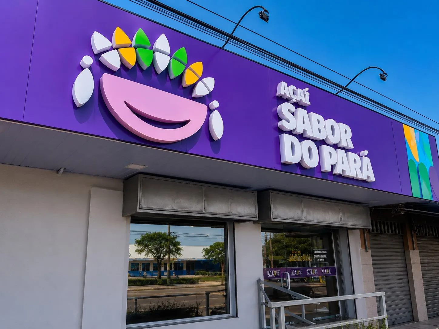 Fachada roxa com revestimento, símbolo colorido e letras-caixa Açaí Sabor do Pará