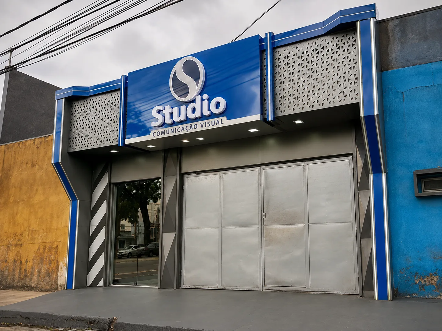 Fachada azul da Studio Comunicação Visual com letreiro branco