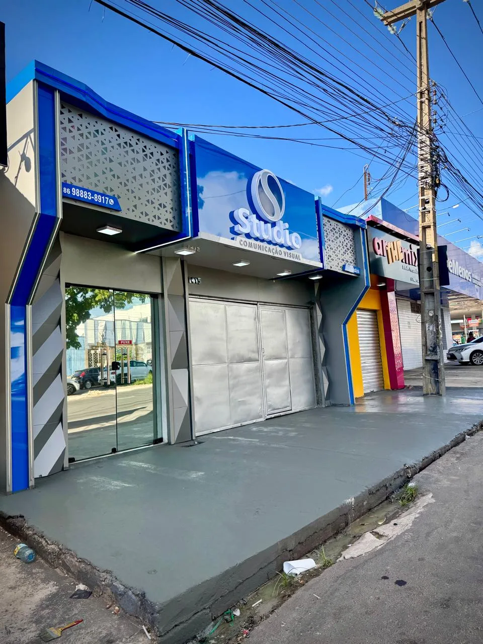 Fachada da Studio Comunicação Visual em Teresina, com revestimento azul, letreiro e entrada de vidro